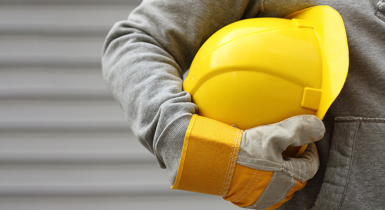 ヘルメットを抱えた作業員